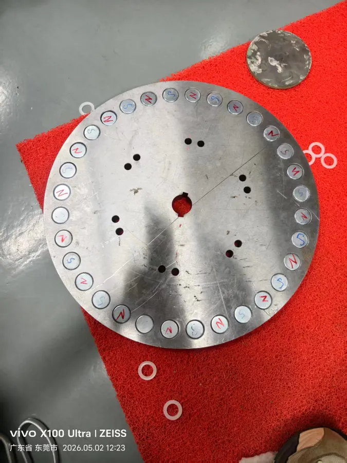 The machined steel rotor plate with magnet pockets, on the workbench